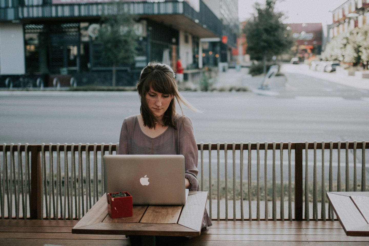 woman_in_gray_shirt_sitting_on_bench_in_front_of_macbook - ©christinhumephoto